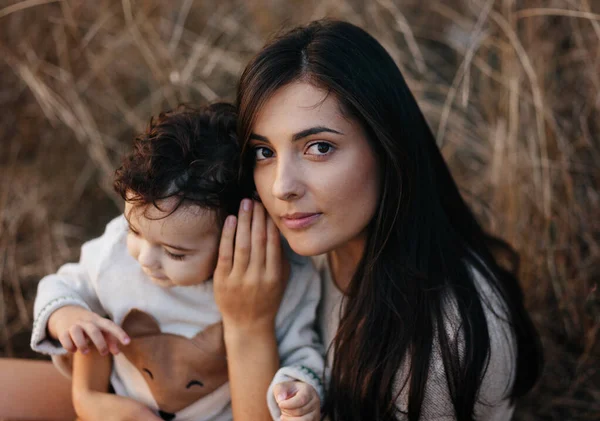 Niño y su madre caminando en el parque de otoño. Madre abraza a su niño pequeño — Foto de Stock