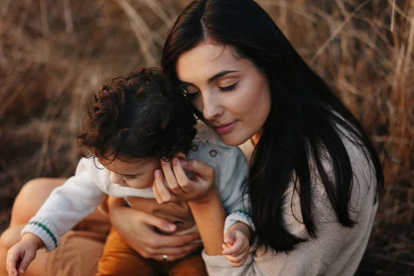 Niño y su madre caminando en el parque de otoño. Madre abraza a su niño pequeño —  Fotos de Stock