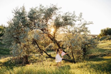 Güzel anne ve küçük kızı dışarıda. Doğa. Güzel anne ve çocuğu parkta birlikte oynuyorlar. Mutlu bir ailenin açık hava portresi. Anneler Günün kutlu olsun. Anne ve Bebek. Hasır şapkalı kadın.