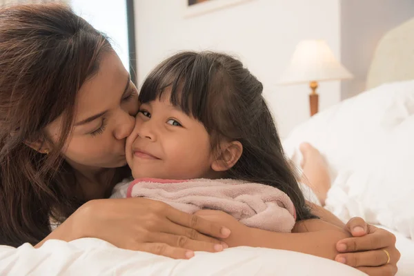 Mother and daughter enjoy in bed at home