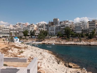Agios Nikolaos Körfezi'nin kayalık kıyı şeridi, Saronik Körfezi, Ege Denizi, Tekneler ve Pire'deki Agios Nikolaos Şapeli, Attika, Yunanistan