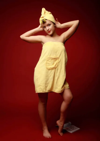 年轻的妇女与卷发站在红色的背景下 摆姿势被黄色毛巾覆盖 引式复古式全增长肖像画 — 图库照片