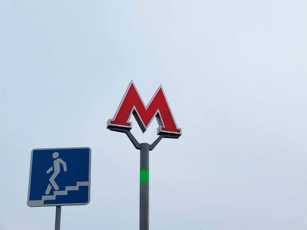 Red M Letra Moscú Metro signo y metro paso subterráneo a la línea 2 contra el fondo del cielo —  Fotos de Stock