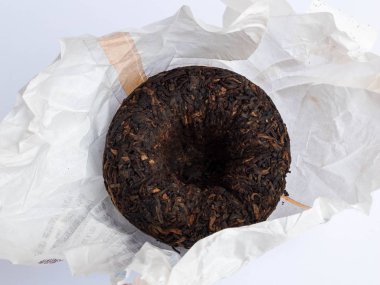 Beyaz arka planda sarma kağıt üzerinde preslenmiş Tuocha Puer çay yakın çekim
