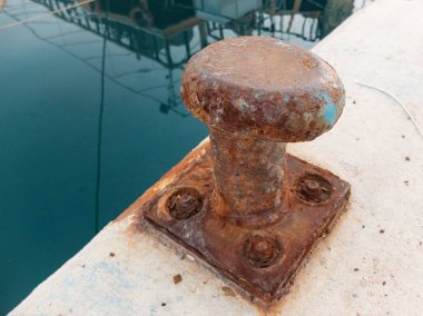 Bir iskelenin kenarında eski paslı demirleme bollard