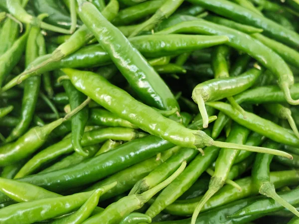 Green hot spicy chili peppers at the market counter