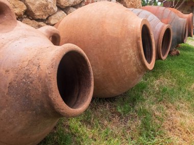 Taş duvara karşı yeşil çim üzerinde Antik seramik amforalar