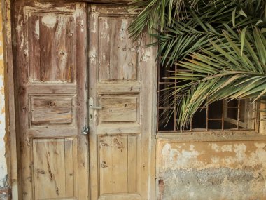 Pencere ve ahşap kapılar üzerinde barlarla eski terk edilmiş taş konak