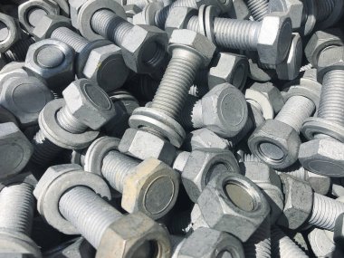 Kutu içinde yığılmış çelik fındık ve vidalar. İnşaat ekipmanlarını sabitleme. Donanım sabitleme