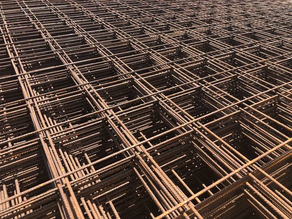 Piled iron reinforcement workpieces. Metal mesh for reinforcement. Iron rusty rectangular structure