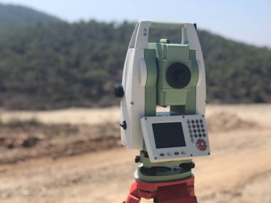 Bulanık arka plana karşı inşaat alanında jeodezik toplam istasyon