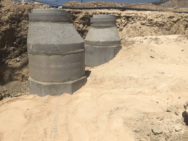 Storm water drainage reinforced concrete wells in the dug trench. Water drainage system under construction