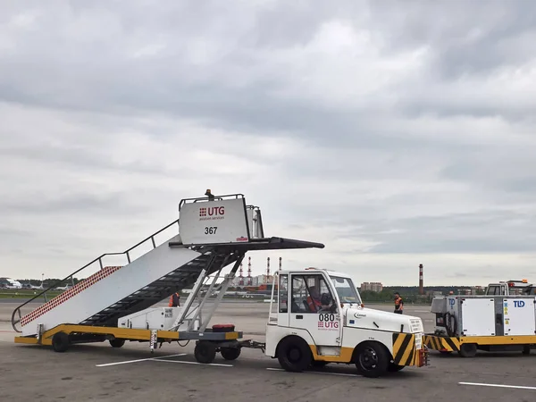 The airport car transports the plane ladder on the airfield. Vnukovo airport, Moscow - May 2019