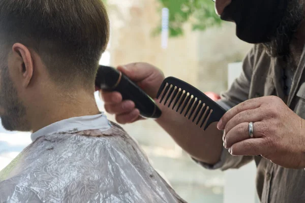 Zamaskowany Fryzjer Obcina Włosy Człowiekowi Maszyną Strzyżenia — Zdjęcie stockowe