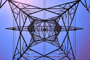 Yüksek voltaj kablolarına sahip metal elektrik hattı direği alt görünümü.