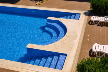 Plastik güneşlikler yüzme havuzunun yanında duruyor..