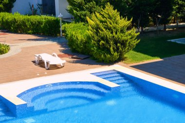 Plastik güneşlikler yüzme havuzunun yanında duruyor..