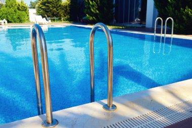 Yüzme havuzunun el rayları. Metal yüzme havuzu merdiveni.