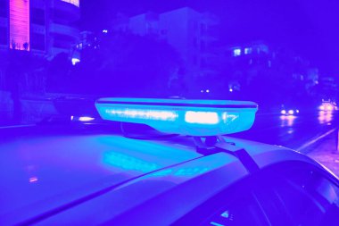 Polis arabasının gecenin karanlığında yanıp sönen ışıkları seçici odak.