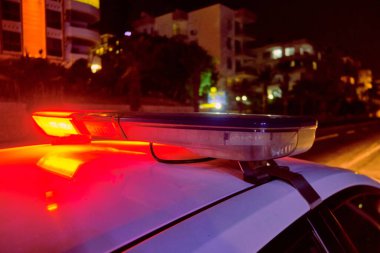 Polis arabasının gecenin karanlığında yanıp sönen ışıkları seçici odak.