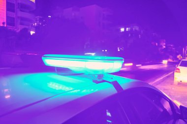 Polis arabasının gecenin karanlığında yanıp sönen ışıkları seçici odak.
