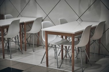 Kafedeki beyaz tabureler ve beyaz masalar