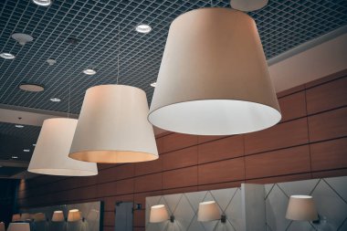 Havaalanındaki kafede koni gölgesinde lambalar