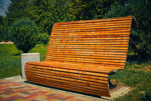 Drewniana ławka z wysokim oparciem w parku — Zdjęcie stockowe