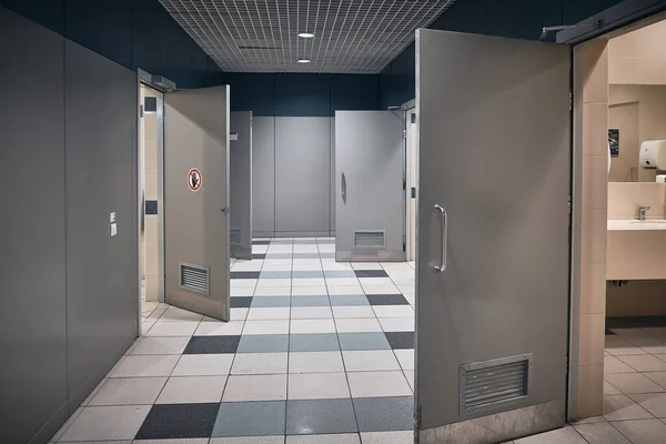 Toilet hallway with open doors in an airport.