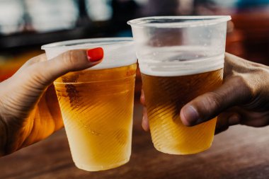 Bira randevu. Bir el manikür olan bir kadın ile bir plastik bardak bira ile tutar. Adamın han ikinci cam
