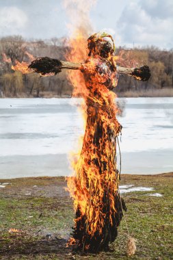 Slav tatil kış sonu. Saman büyük bir Shrovetide bebek nehir kıyısında yakar. Siyah duman görünür