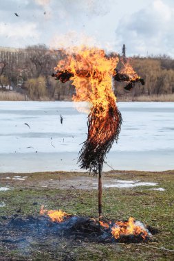 Slav tatil kış sonu. Saman büyük bir Shrovetide bebek nehir kıyısında yakar. Siyah duman görünür
