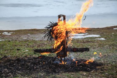 Slav tatil kış sonu. Donmuş nehir kıyısında, gözleme saman bir büst kalıntıları wee