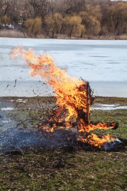 Slav tatil kış sonu. Donmuş nehir kıyısında, gözleme saman bir büst kalıntıları wee