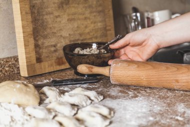 Mermer masa üstü yalan çiğ köfte ve beyaz un hamur bir parçası. El bir cam kase bir rüyamı ile savaşır