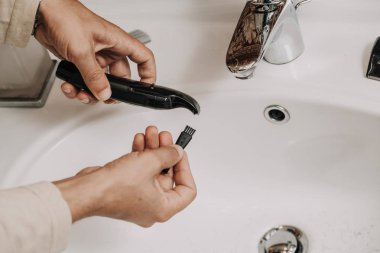 Temizlik sakal kesme makinesi. Temiz eller erkek düzeltici özel bir fırça ile modern bir washbasi üzerinde