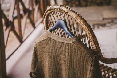 Sonbahar hikayesi. Bir askı bir hasır sandalye arkasında verand üzerinde bir yün örme ceket asmak