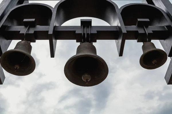 Drie Kerkklokken Hangen Een Stalen Basisstuk Onderaanzicht Tegen Bewolkte Hemel — Stockfoto