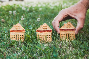 inanılmaz şirin bir evi. Bir ev şeklinde üç çerezleri üzerinde yeşil çayır yakın dur. Adamın elini koyar bir hous