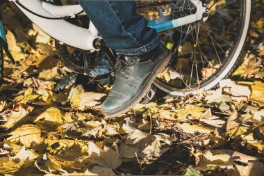 Bacak ayakkabı modern bisiklet pedalı üzerinde orman yakın çekim sonbaharda adamdır. Abov görüntülemek