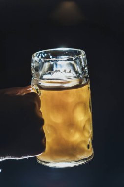 sağ kolum cam kupa arka ışık yakın u'amber bir bira ile tutar