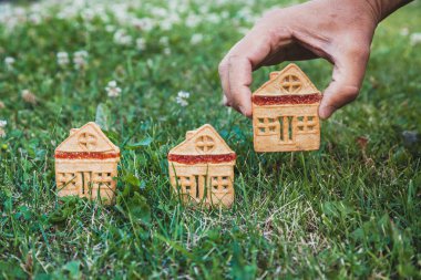 inanılmaz şirin bir evi. Bir ev şeklinde üç çerezleri üzerinde yeşil çayır yakın dur. Adamın elini koyar bir hous