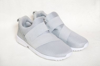 Bir beyaz izole arka plan üzerinde iki yeni ışık gri spor ayakkabı bir kafes top ile stand