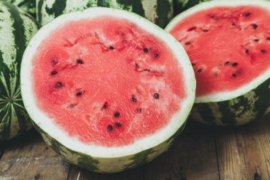 Sonbaharın meyveleri. İki yarım kesilmiş kırmızı karpuz çizgili yeşil beyaz karpuz kapat-u bir arka plan üzerinde yalan