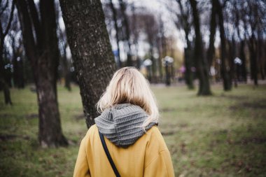 parlak sarı moda ceket ince sarışın sonbahar bir parkta yürüyor. Bac görüntülemek