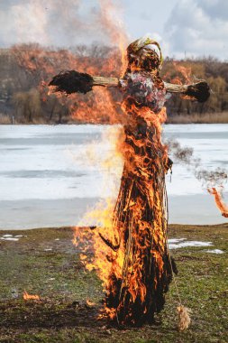Slav tatil kış sonu. Saman büyük bir Shrovetide bebek nehir kıyısında yakar. Siyah duman görünür