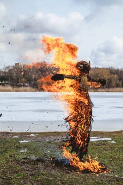 Slav tatil kış sonu. Saman büyük bir Shrovetide bebek nehir kıyısında yakar. Siyah duman görünür