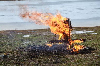 Slav tatil kış sonu. Donmuş nehir kıyısında, gözleme saman bir büst kalıntıları wee