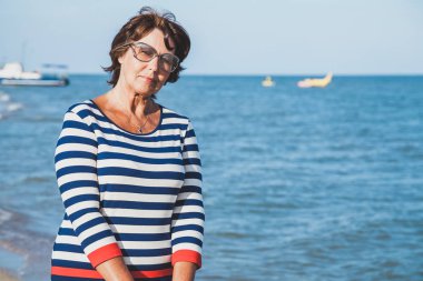 Güneş gözlüğü tatilde deniz gemi arka plan üzerinde oldukça yaşlı kadın