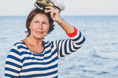 Sahilde deniz bir kap içinde oldukça memnun yaşlı kadın 